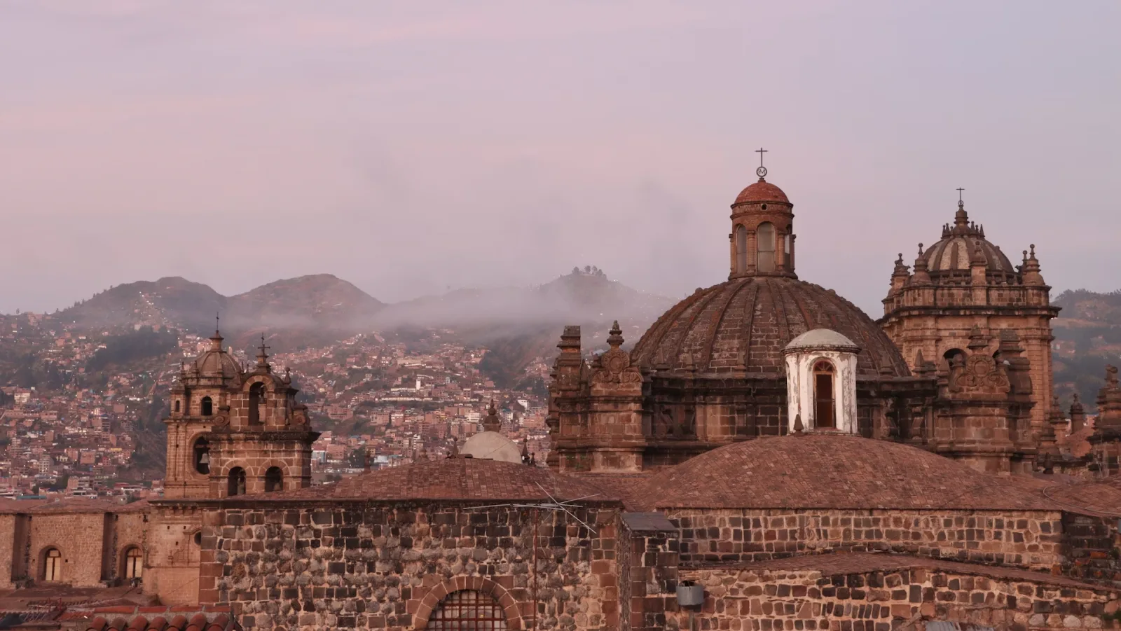 Sunset over Cusco rooftops with the Andes in the distance